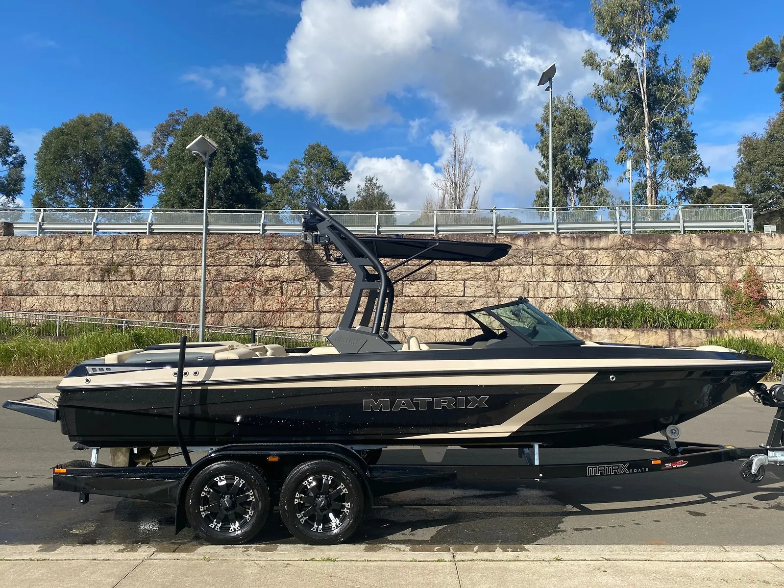Black and sand MXV on its trailer, side on